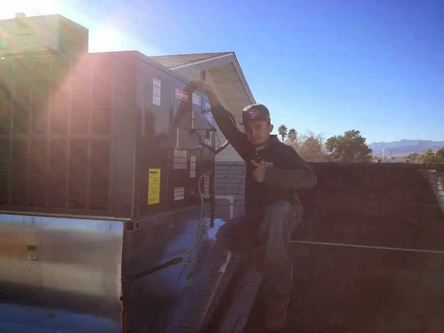 HVAC technician performing HVAC Inspection on a rooftop unit in Plover